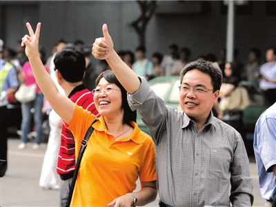 北京一考点外，两位家长在目送孩子进入考场后，不忘作出鼓励的手势