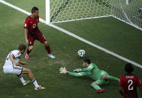 Germany's Thomas Mueller (L) shoots to score against Portugal for his hat-trick during their 2014 World Cup Group G soccer match at the Fonte Nova arena in Salvador June 16, 2014. [Photo/Agencies] 