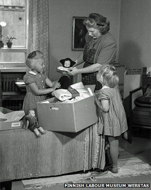 Mother and daughters look at a pack from 1947һλĸ׺Ůڿһ1947Ĳư