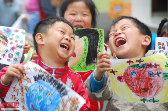 江苏省淮安市一所幼儿园的小朋友展示自己的笑脸主题画作