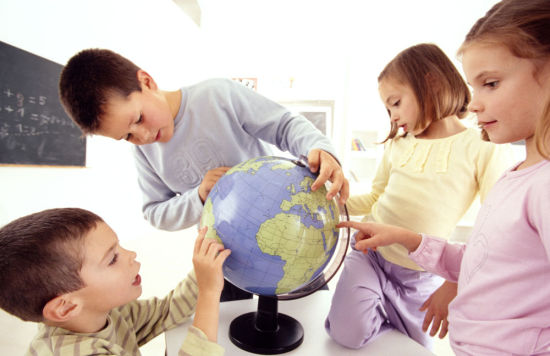 schoolchildren looking at a globe