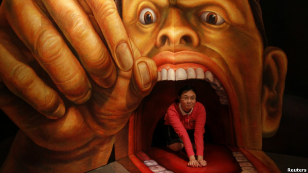 A woman poses for a photograph with a painting during an exhibition in Taipei.
