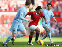 Carlos Tevez of Manchester United surges forward with the ball