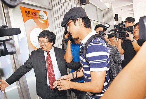 　　明道(中)去年9月到学院上课时被媒体包围，该校主任秘书引导他进教室。图片来源：台湾《苹果日报》