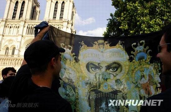 图文:歌迷悼念--在巴黎圣母院前高举画像