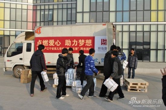 图为 孤儿院学校的孩子们欢快的搬运书籍