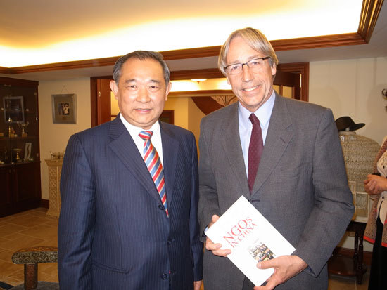图为2.中国世界和平基金会主席李若弘先生赠送《中国NGO》一书给红十字国际委员会东亚地区代表处主任蒂埃里•梅拉先生