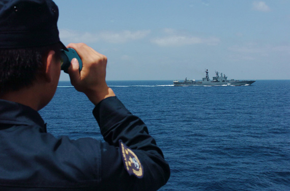 9月18日，在亚丁湾西部海区，中国海军第三批护航编队“舟山”舰一名中国海军战士正在通过望远镜观察“特里布茨海军上将”舰的旗语。新华社记者郭刚摄