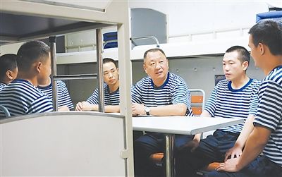 7月27日,记者在"昆仑山"舰摄下了支队长纪洪涛(左三)下连当兵参加班务