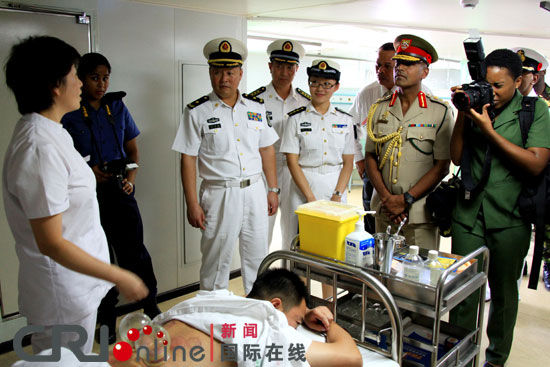特国防军总参谋长马哈拉吉准将（右前2）在参观我医院船的中医展示。毛宇摄