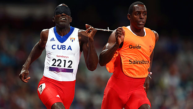 Yaseen Perez Gomez guides Arian Iznaga of Cuba around the track in the men's 200m, T11 race. 