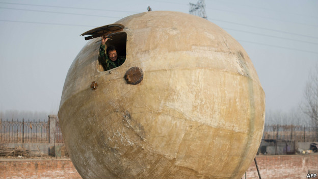 A Chinese farmer in a large ball called a 'survival pod'.
