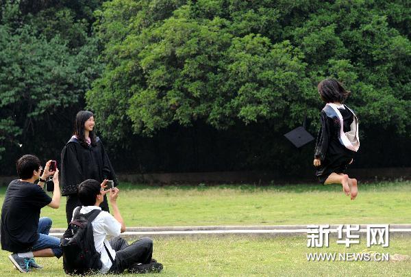 5月20日,一名毕业生在校园里跳跃留影.新华社记者孙参摄