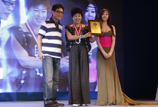 2009蓝色盛典时代骑士勋章得主于丹（中）,女演员巩新亮(miumiu)为于丹颁奖