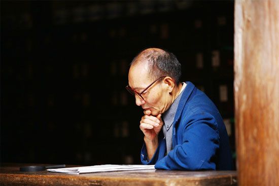 悠闲看报的老者