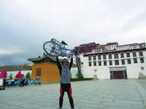 Huang Haixing in front of the Potala Palace to lift his bicycle.