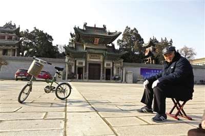 An old man in the sun Shan Shan hall in front of the square. Here have witnessed the prosperity and decline of Liaocheng business.