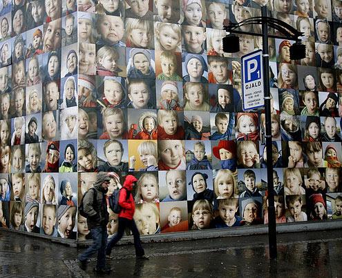 雨中,冰岛雷克雅未克市的街上,有面墙满是孩子笑脸.
