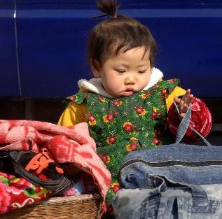 图为小女孩在福州火车站护守行李。