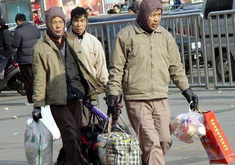 三位农民工刚从郑州火车下车出站，准备返乡过春节。