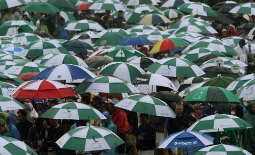 图文-名人赛第三轮暴雨突袭 撑伞人群