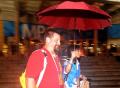 图文-北京突降大雨 MPC志愿者帮国外记者撑红雨伞