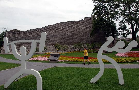 图文-北京古城墙下的奥运元素 市民在奥运造型旁跑步