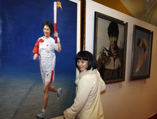 正文 12月17日,奥运冠军高敏与画有自己风采的油画作品合影