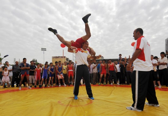 图文-奥运冠军与西藏群众互动 哈那提将对手扛