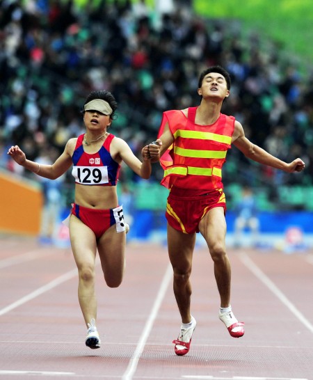 12月14日,中国选手贾君婷仙(左)和领跑员在比赛中.