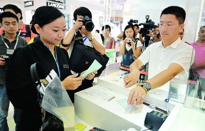 图为4月19日,三亚免税商店的工作人员正在演示离岛免税购物流程.