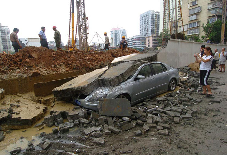 图文:工地围墙倒塌压扁轿车砸伤路人