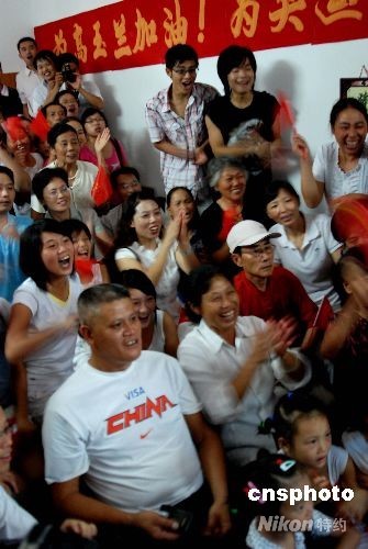 高奉木(左一)和母亲王能荣(左二)在江西家乡的电视机前为女儿加油助威