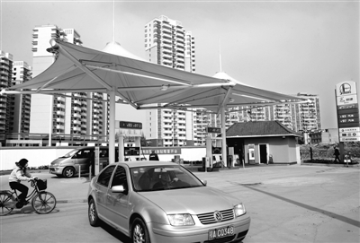 昨日,在汉口仁寿路一座新落成的"绿岛型加油站"前,加油的车辆进进出出