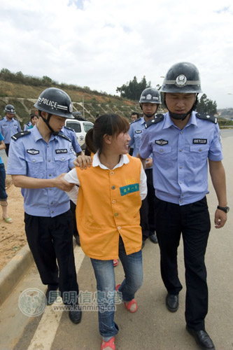 一名女嫌疑人嬉笑着指认现场 实习生杨帆/摄