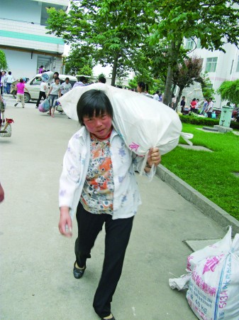 一位家長正在扛著行李幫孩子離校. 本報見習記者 王偉強 攝