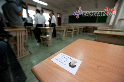 图为控江中学考点内,考场桌上贴着印有考生照片的准考证副本,方便考生