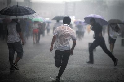 昨日,北京火车站广场,正在雨中奔跑的人们侯少卿 摄