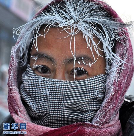 11月29日,在内蒙古呼伦贝尔牙克石街头,一名妇女头发,眉毛结满冰霜