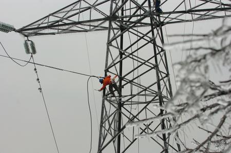 图文:电力抢修人员在高压线塔上