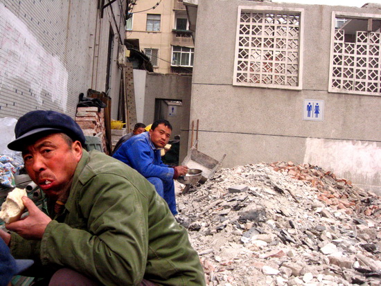 图文:整修厕所的农民工吃午餐