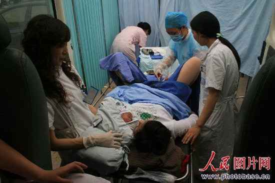 5月12日下午,眉山市第二人民医院医务人员在临时产房里为一妇女接生