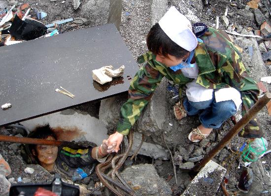 图文:护士在北川地震现场安慰被深埋的男孩