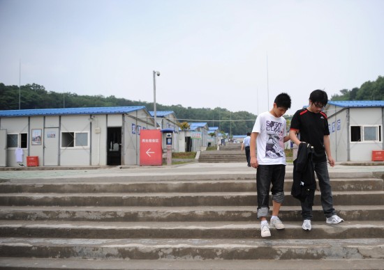 图文:廖波在李阳的搀扶下离开学校