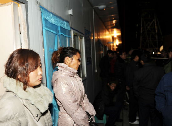 两名矿工家属在铜川发生瓦斯爆炸事故的井口焦急等待.