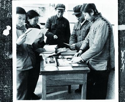 上世紀70年代,居民圍著下社區服務的郵局人員辦業務(資料圖) 攝/法制