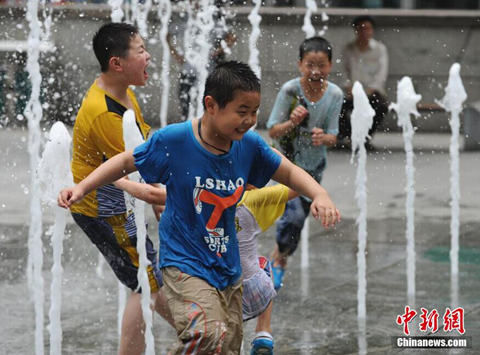 28日,重庆高温天气持续,位于解放碑的一处喷泉成为小朋友们戏水消暑的