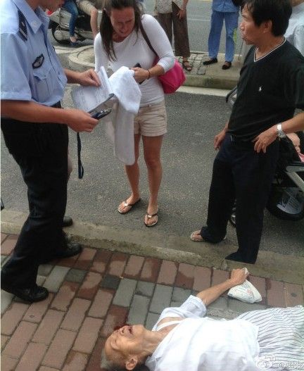 老人晕倒街头,外国女子给其头下垫毛巾.(来源:网络)