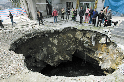 昨日,沙区歌乐山镇天池村,村民陈天福家门前地陷形成的大坑 记者 唐浩