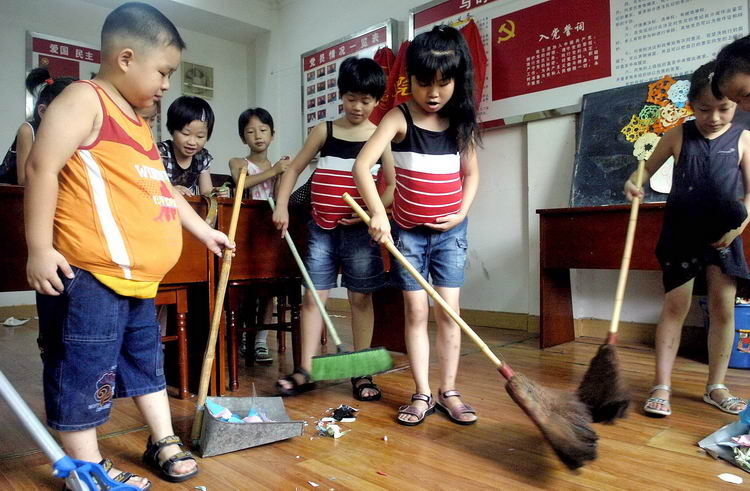 十餘名小朋友裝扮成大肚子孕婦模樣打掃衛生,以體驗母親十月懷胎的